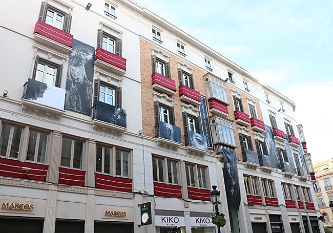 Fachada adornada de uno de los edificios de la calle Larios para la procesión de la Virgen de la Trinidad.