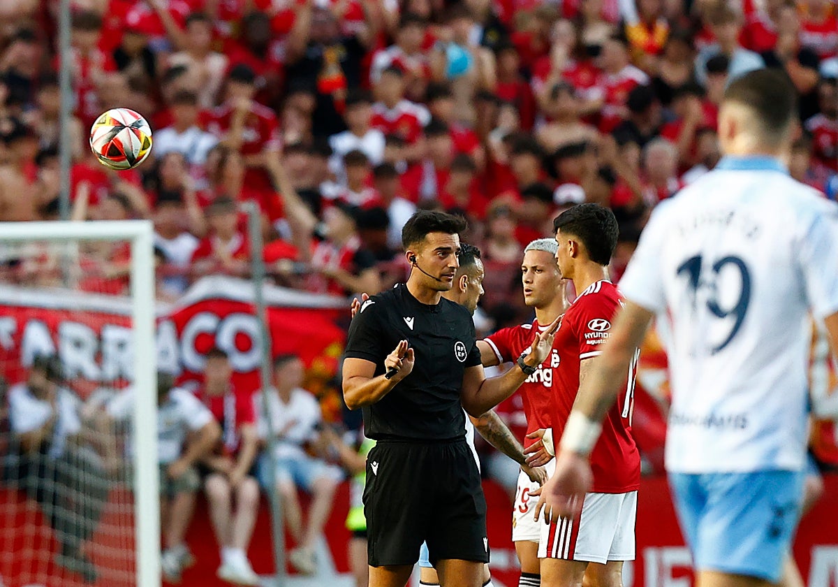 Eder Mallo dialoga con jugadores del Gimnástic en el partido en Tarragona, en el que el Málaga ascendió a Segunda División.