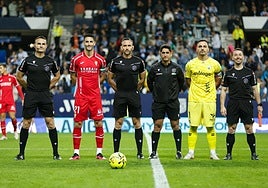 Orellana Cid, en el centro de la imagen, junto a sus asistentes Ramos (cántabro, a la izquierda) y Sarmiento Millet (veleño, a la derecha de la imagen),con el cuarto árbitro, Palomares (linense), a su lado, y los capitanes de los equipos, Alfonso Herrero y Albarrán, en una foto para la historia.