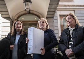 Las hermanas García Caparrós con una de las cajas con la documentación, este martes en el Congreso de los Diputados.