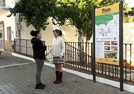Dos responsables municipales conversan junto a uno de los nuevos paneles informativos.