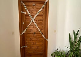 La puerta de la vivienda, acordonada por la Guardia Civil tras el crimen.