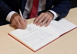 De la Torre firmando un documento en una imagen tomada recientemente.
