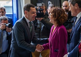 Juanma Moreno saluda a María Jesús Montero a su llegada al acto.