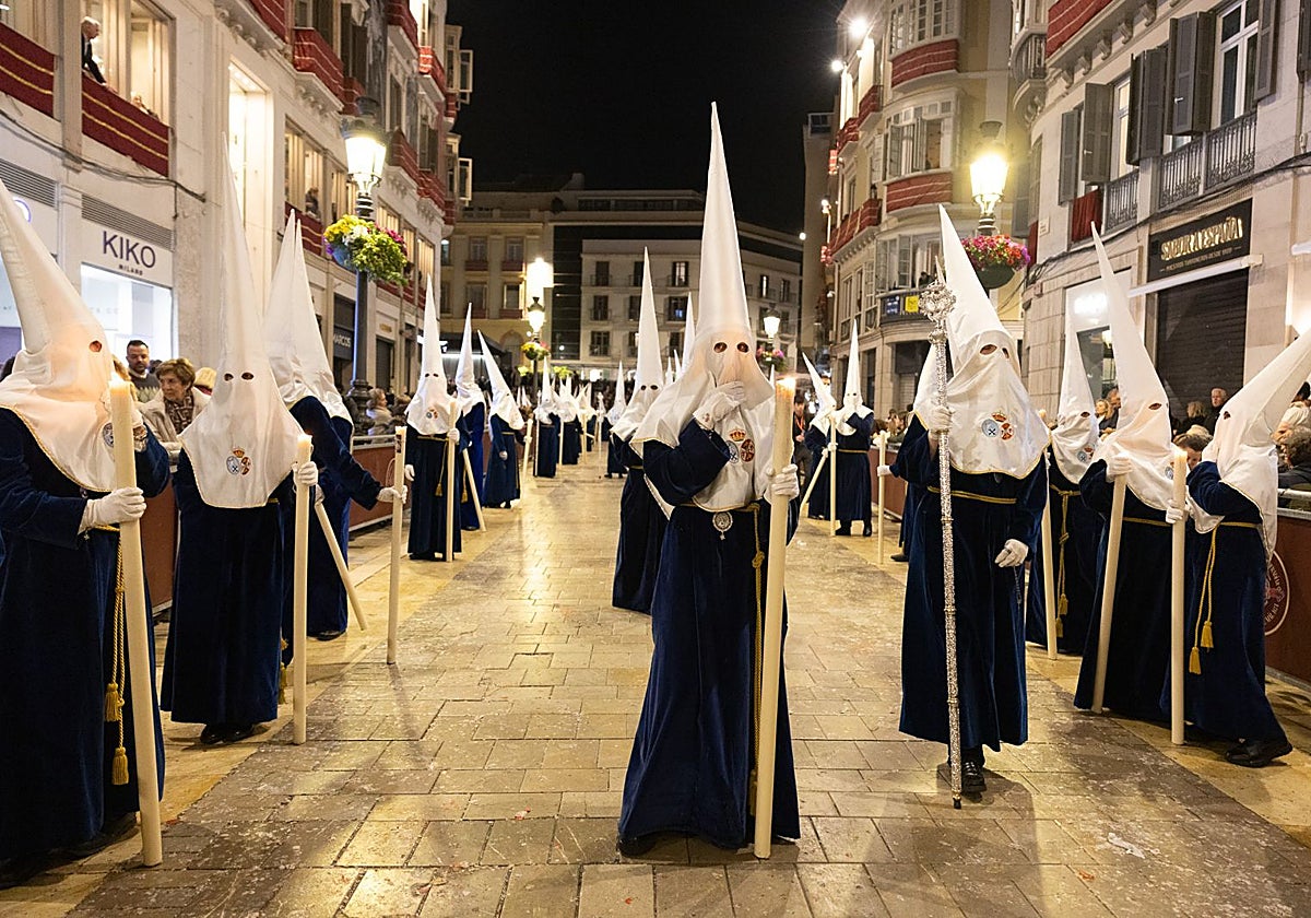 La Cofradía de la Paloma puso sus nazarenos en filas de a tres en el recorrido oficial.