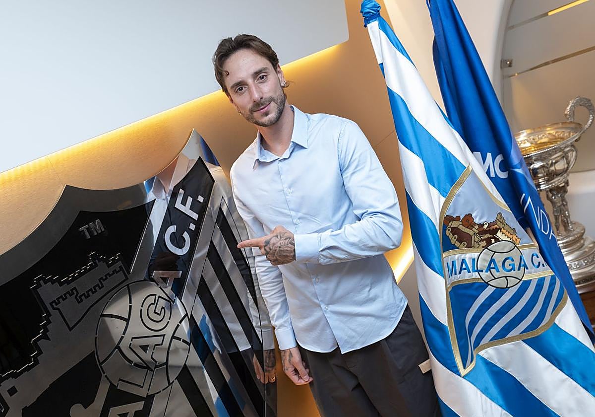Fernando Calero posa con el escudo y la bandera del Málaga.