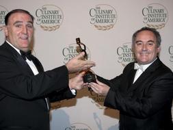 El cocinero español Ferran Adriá (d) recibe de su colega y compatriota José Ramón Andrés Puerta (i) el premio de "chef del año" con el que se reconoce su labor e innovación en el Arte Culinario en Nueva York. / Efe