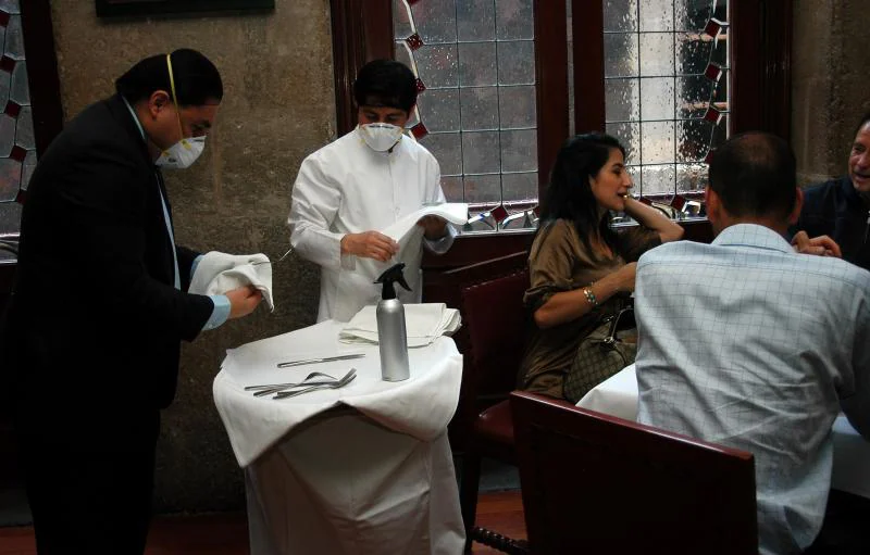 Los camareros mantienen precauciones de higiene ante sus comensales durante el segundo día de actividades en la reapertura de restaurantes en Ciudad de México. / Efe