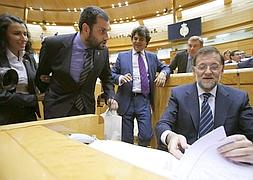 El senador Ibán García del Blanco, intenta entregar un casco de minero a Rajoy. / Efe | Atlas