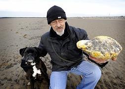 Ken Wilman, junto a su perro, y la pieza de ámbar gris. / AFP