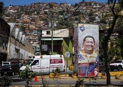 Transeúntes pasan frente a publicidad en apoyo del presidente venezolano, Hugo Chávez./ M. Gutiérrez (Efe)