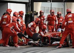 Los mecánicos de Ferrari atienden a Alonso en el GP de Baréin. / Mohammed Al-Shaikh (Reuters)