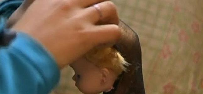 Una niña juega con una muñeca. / Atlas