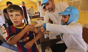 Un niño sirio refugiado es atendido por los servicios médicos en el campo de Qurn Gusik. / Efe