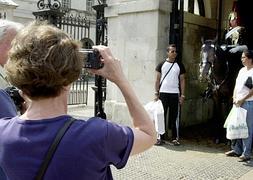 Turistas posando junto a un guardia antes del cambio de guardia inglesa. / Richard Lewis (Ap)