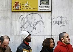 Varias personas hacen cola ante la oficina del INEM en Madrid. / Archivo