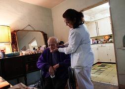 Una mujer atiende a un anciano dependiente. / R. C.