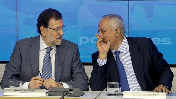 Rajoy (i) conversa con Arenas al inicio de la reunión.