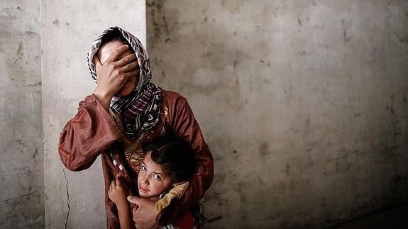 Una mujer siria abrazada a su hijo. 
