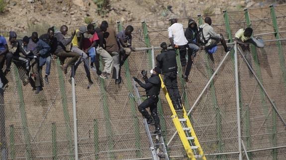 Varios inmigrantes encaramados a la valla de Melilla se han bajado de la verja y han sido entregados a Marruecos