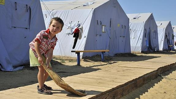 Un niño ucraniano limpia el suelo en un campo de refugiados en el área de Rostov. 