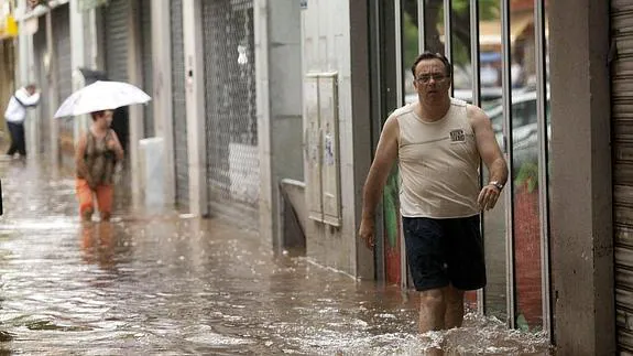 Un hombre camina por una de las calles de Santa Cruz de Tenerife inundadas. 