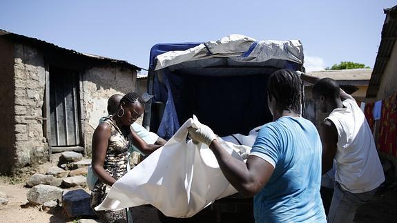 Trabajadores sanitarios trasladan el cuerpo de una víctima en Guinea. 