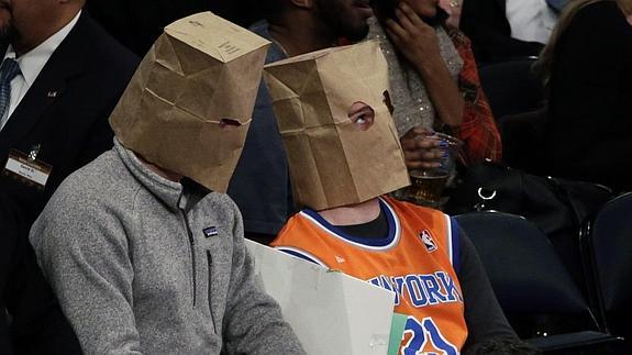 Aficionados de los Knicks, cubiertos con bolsas de papel. 