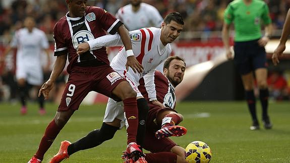 Reyes (c) lucha por hacerse con la pelota entre dos jugadores del Córdoba. 