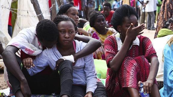 Estudiantes que lograron ser rescatados se consuelan mutuamente en el campamento militar de Garissa. 