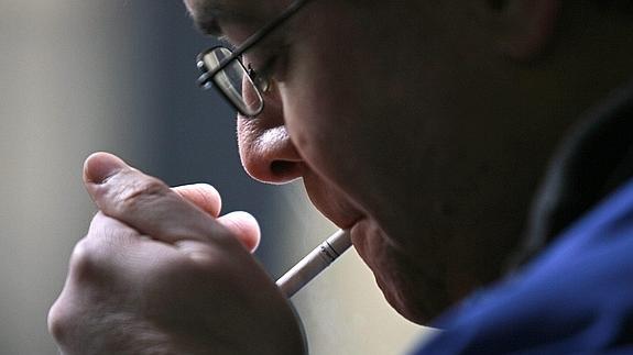 Un hombre se enciende un cigarro.