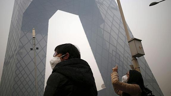 Dos viandantes con mascarillas en Pekín.