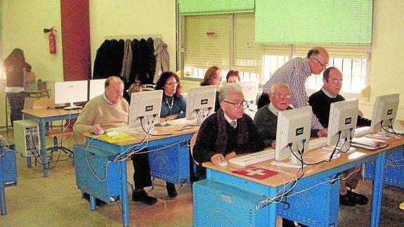 Un grupo de personas mayores se familiariza con las nuevas tecnologías, cada vez más relevantes para una formación integral.