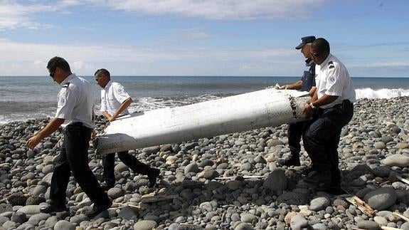 Varios policías trasladando restos del avión.