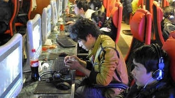 Jóvenes chinos consumen contenidos audiovisuales en un cibercafé.