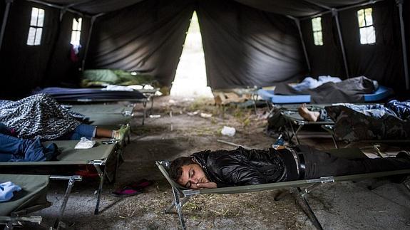 Refugiados duermen en el interior de una tienda en un campamento.