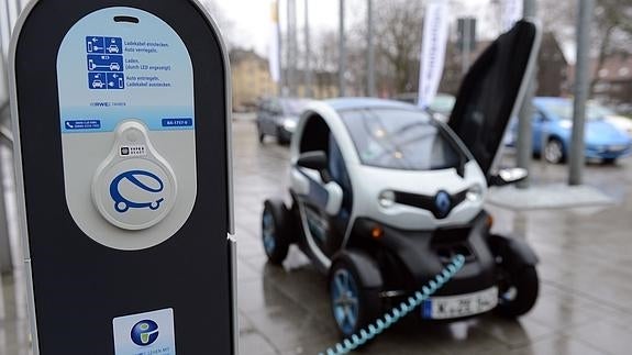 Coche eléctrico recargándose en una gasolinera.