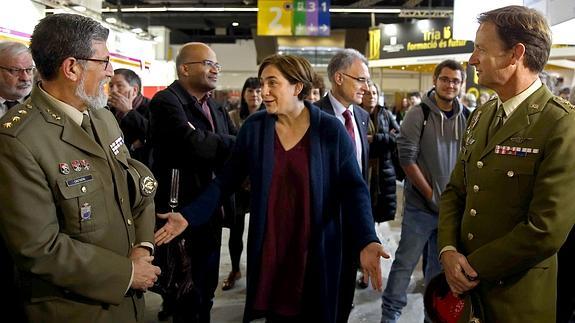 Ada Colau conversa con dos mandos militares en el stand que Defensa había instalado. 