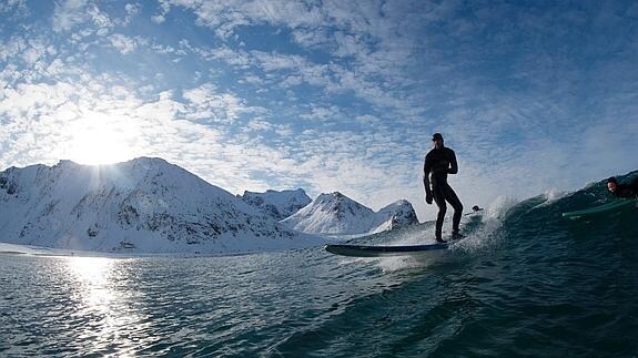 Una persona haciendo surf en el Círculo Polar Ártico. 