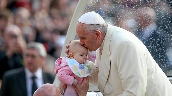 El papa Francisco besa a un bebé durante la audiencia general de los miércoles. 