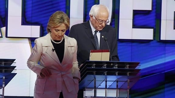 Hillary Clinton y Bernie Sanders abandonan sus atriles al término del debate. 