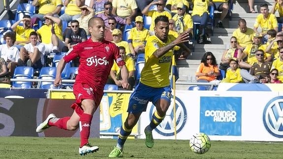 Jonathan Viera (d) persigue la pelota ante el defensa rival Alberto Lora (i). 