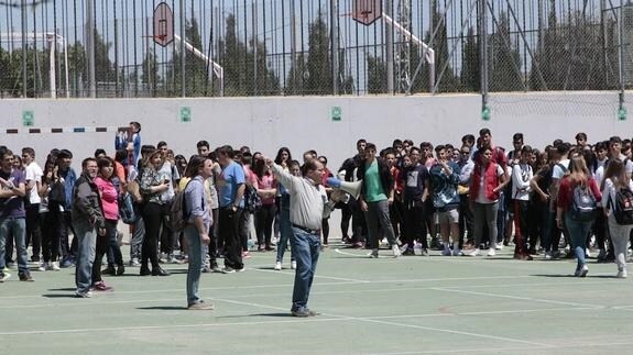 El jefe de estudios del instituto Ramón Arcas Meca da instrucciones con un megáfono a los alumnos durante la evacuación del centro. 