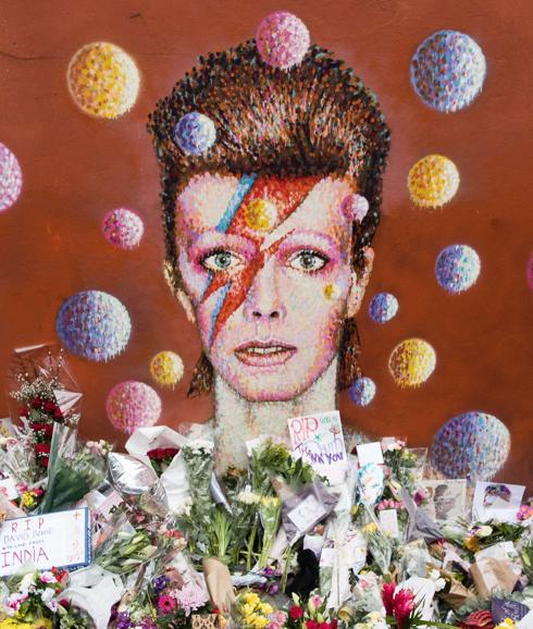 Tributos florales bajo un mural de David Bowie pintado por el artista callejero australiano James Cochran.