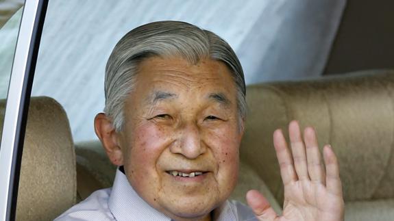 El emperador Akihito saluda desde su limusina.