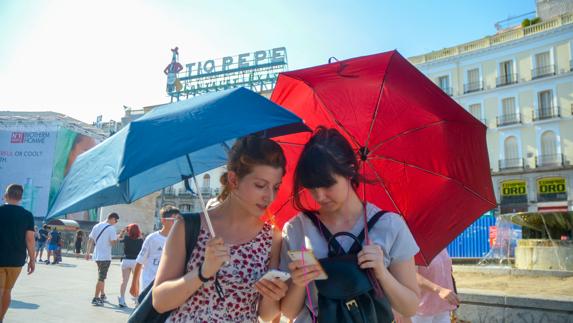 Dos jugadoras utilizan Pokémon Go en la Puerta del Sol.