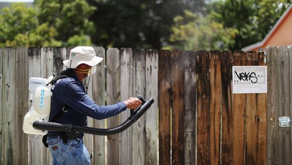 Un operario dispersa larvicidas y pesticidas en patios y jardines del condado de Miami-Dade. 