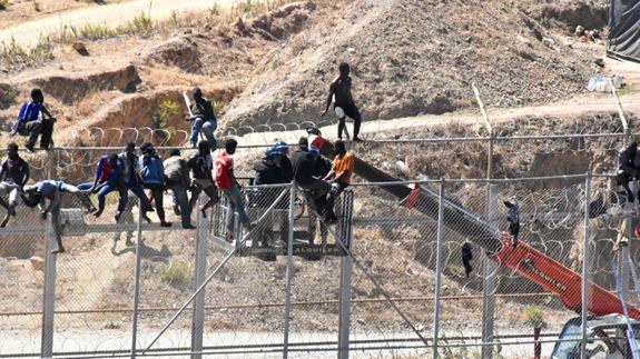 Inmigrantes encaramados a la valla de Ceuta. 