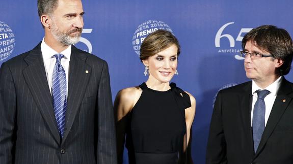 Los Reyes Felipe y Letizia, junto al presidente de la Generalitat de Cataluña, Carles Puigdemont (d).