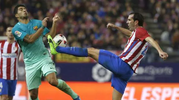 Luis Suárez (i), frente a Godín. 